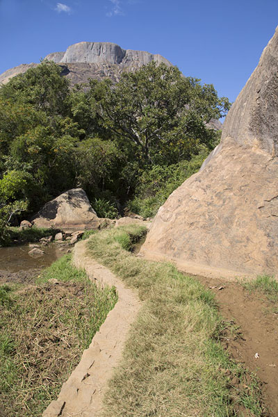Trail under a big boulder with one of the Three Sisters in the background | Anja | Madagascar