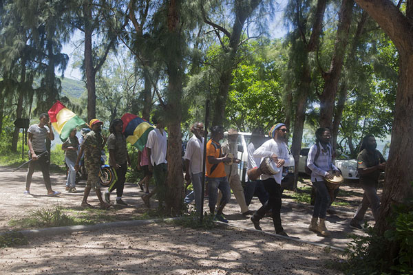Group of people marching along the foot of Le Morne Brabant, commemorating the abolition of slavery, Le Morne Brabant, Mauritius