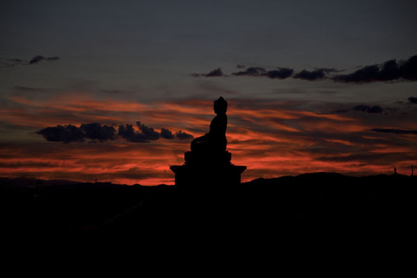 Sunset over a Buddha statue at the Danzandarjaa Khiid at the western part of Mörön, Mörön, Mongolia