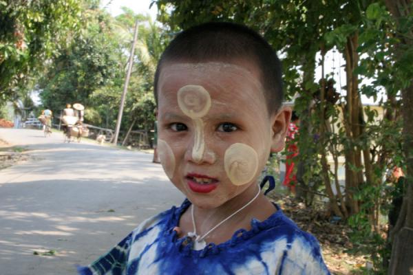 Burmese boy in the street with peculiar forms of tanakha on his face, Myanmar