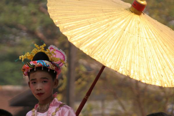 Burmese girl with a golden parasol in a procession, Myanmar