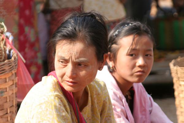 Burmese woman with girl waiting for customers at a street market, Myanmar