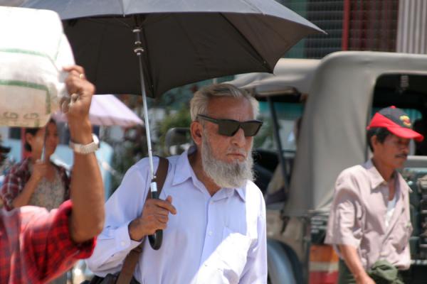 Foto van Myanmar (Burmese man with sunglasses and umbrella standing out from the crowd)