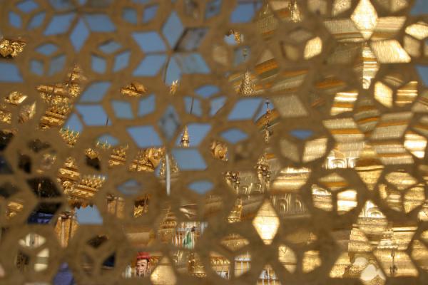 Reflection of the main golden stupa in the intricate mirrors of the temple | Pathein | Myanmar