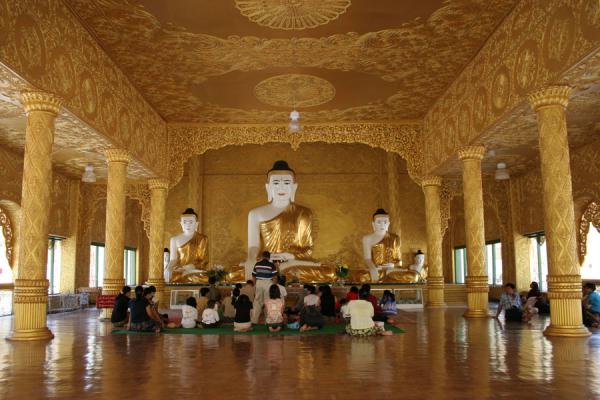 Picture of Buddhists gahtering at the main Buddha statue in the main hall of Shwenokhtaw Pagoda in Pathein - Myanmar - Asia