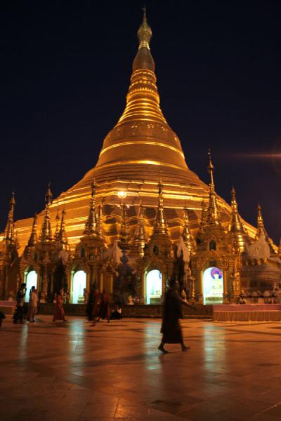 Foto van Monk walking past the stupa of Shwedagon Pagoda after sunsetMyanmar - Myanmar