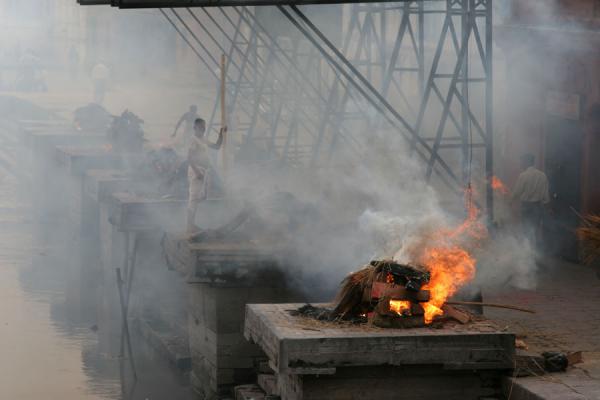 Picture of Fire burning while someone tries to revive another fireKathmandu - Nepal