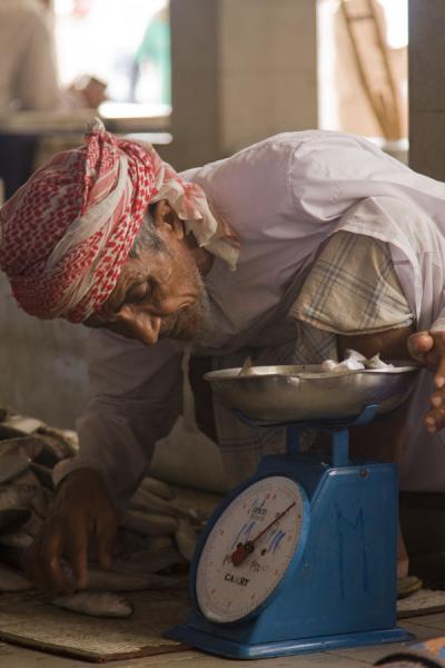 Old Omani checking the scale, Oman