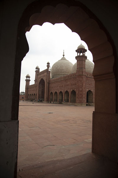 Picture of Badshahi Mosque seen through one of the arches in the corridor on the sideLahore - Pakistan