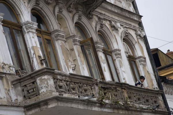 Boy looking down from the balcony of his house, Lipscani historic quarter, Romania
