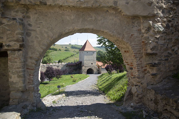 Gate with view of a tower behind it | Alcázar de Rupea | Rumania
