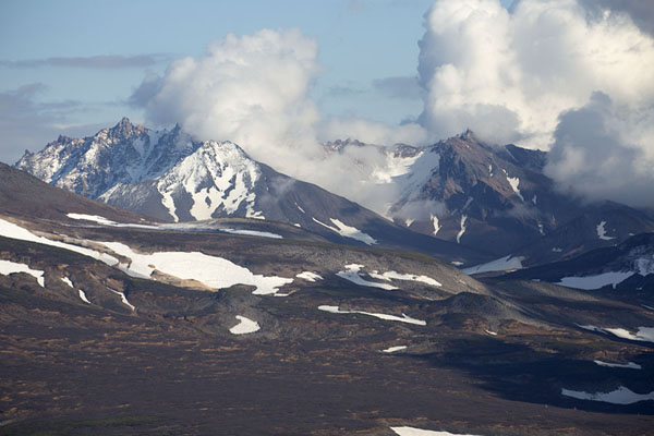 Clouds and snow-covered mountains in central Kamchatka, Kamchatka from the air, Russia