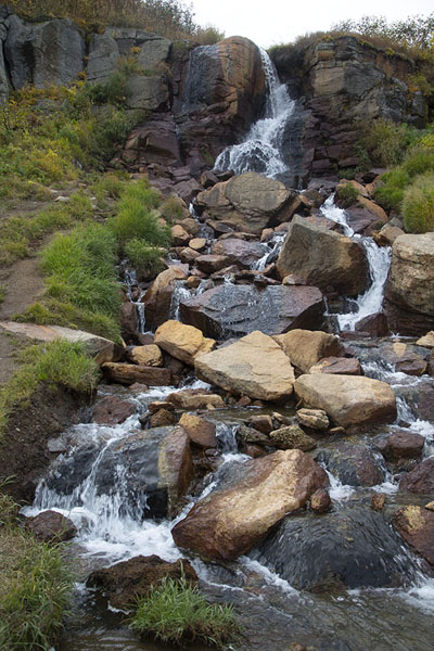 Waterfall with hot water just above the hot pool near the small Valley of the Geysers | Mutnovsky Valley of Geysers | Rusland