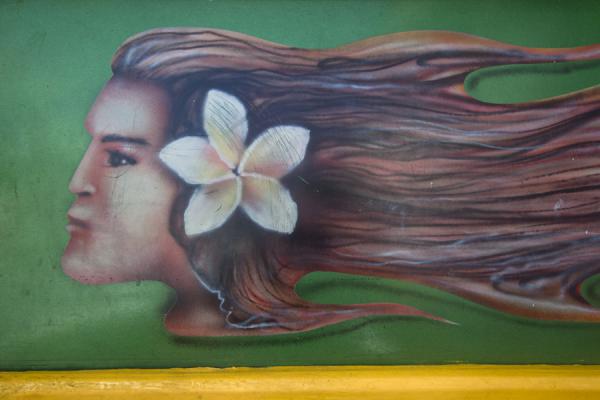 Close-up of the decoration on a bus with a girl and a frangipane flower in her hair, Samoa