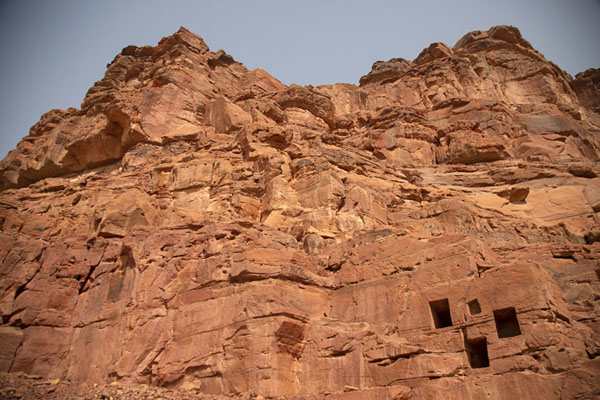 Looking up part of Jebel Khuraybah with some of the many tombs in the rock face | Dadan | Saudi Arabia