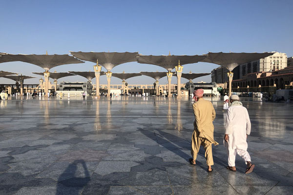 View of the enormous open plaza of the Prophet Mosque with umbrellas and worshippers, Medina mosques, Saudi Arabia