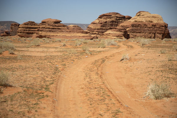 Rocky mountains with sandy track near Mushroom Rock, Saudi Arabia Track near Mushroom Rock with rock formations in the distance, Saudi Arabia