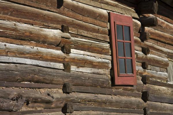Red window in the wall of a rustic wooden cabin | Caminata Cervino | Suiza