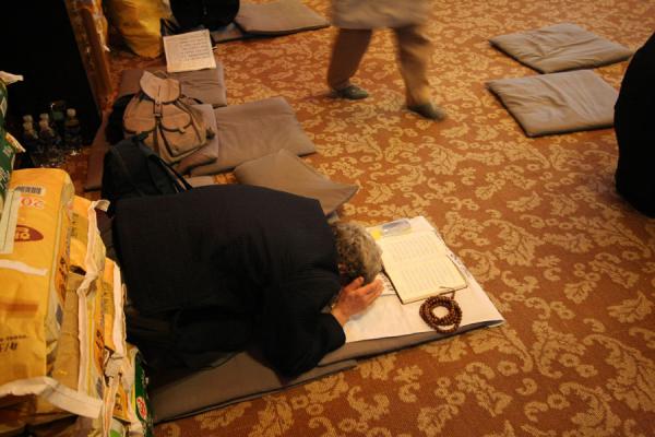 Woman immersed in prayer inside Jogyesa temple, South Korea