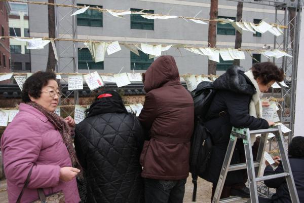 Korean women leaving notes outside Jogyesa temple, South Korea