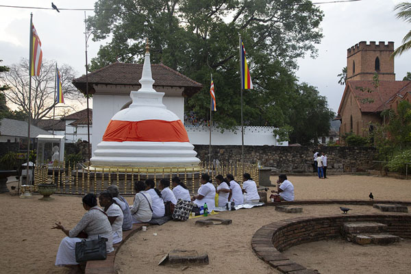 Foto di People sitting in a semi-circle in the temple grounds directly west of the Temple of the Sacred ToothKandy - Sri Lanka