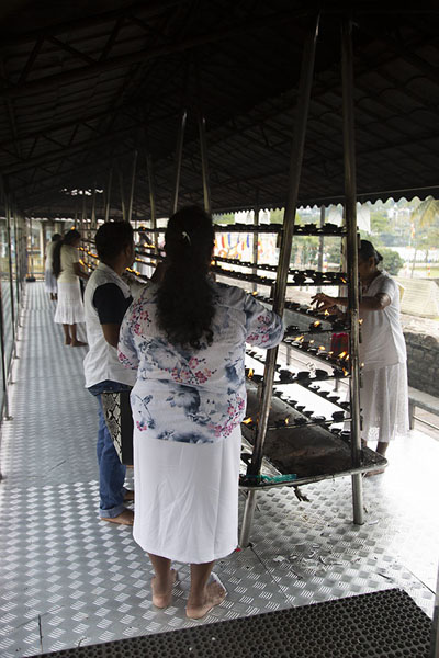 Foto di Women lighting oil lamps in the Temple of the Sacred Tooth complexKandy - Sri Lanka