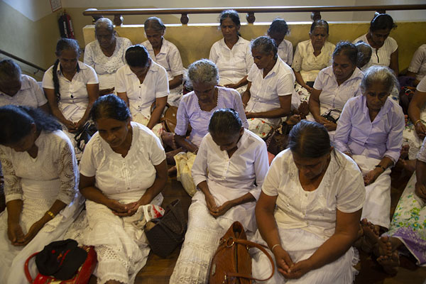 Foto di Women sitting on the floor in prayer in the Temple of the Sacred Tooth RelicKandy - Sri Lanka