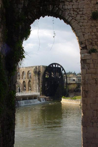 The Al-Mohammediyyeh noria through one of the arches of the aquaduct, Norias, Syria