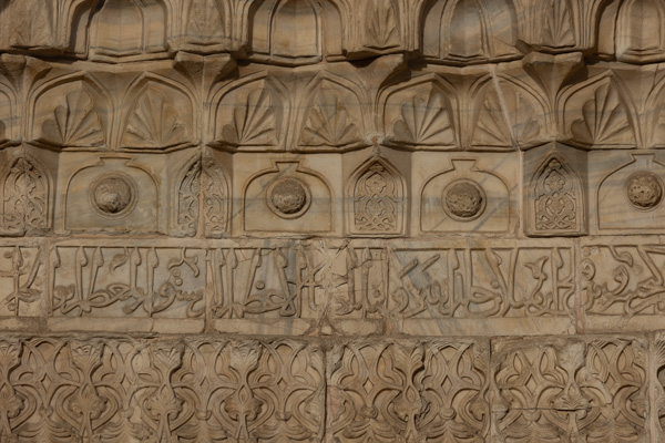 Foto van Muqarnas, rosettes, and a band of Naskh calligraphy in golden sandstone on the outside of Gök MedreseSivas - Turkije