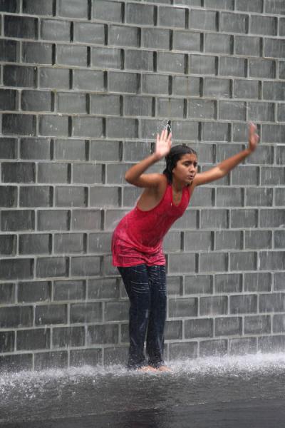 Girl having fun under one of the water towers, United States