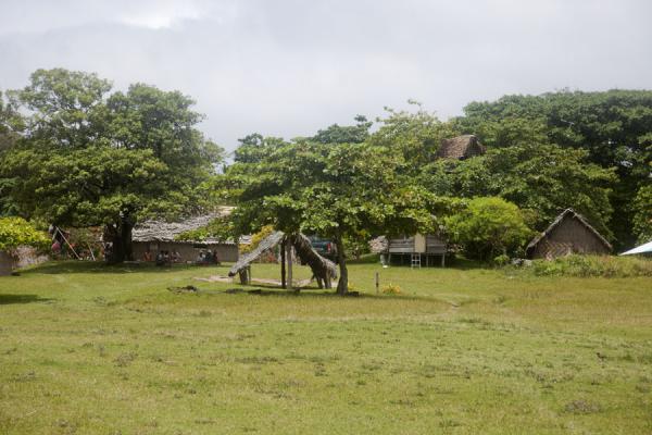 Part of the football field surrounded by traditional houses | Port Resolution | Vanuatu